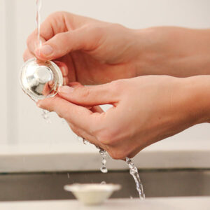 The cleaning of Silver Mama Nipple Cups under cold water