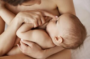 A mother giving the proper latching positions while holding her baby